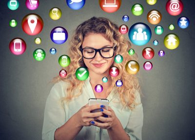a woman with a mobile phone with communication bubbles flowing out of it to depict How to use ChatGPT for content creation