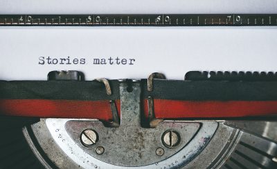 Picture of manual typewriter showing words "stories matter"